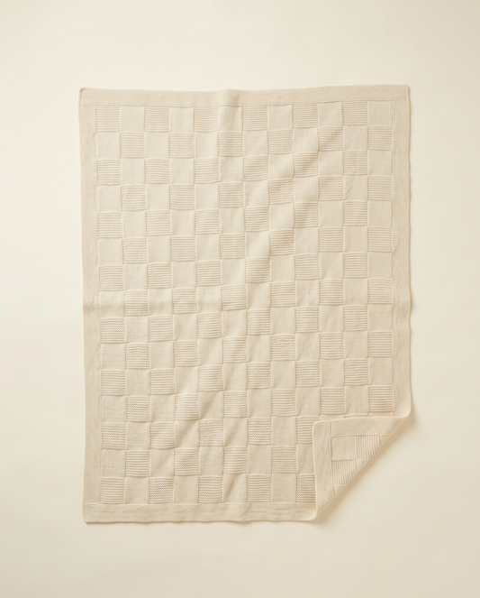 Beige quilted blanket on a beige background